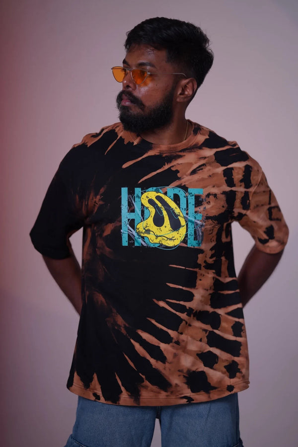 The Damn Denims oversized black and rust-brown tie-dye cotton t-shirt with a vibrant graphic print on a bearded man